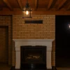 Tuğla duvarlı rustik şömine üzerinde asılı aydınlatma detayı